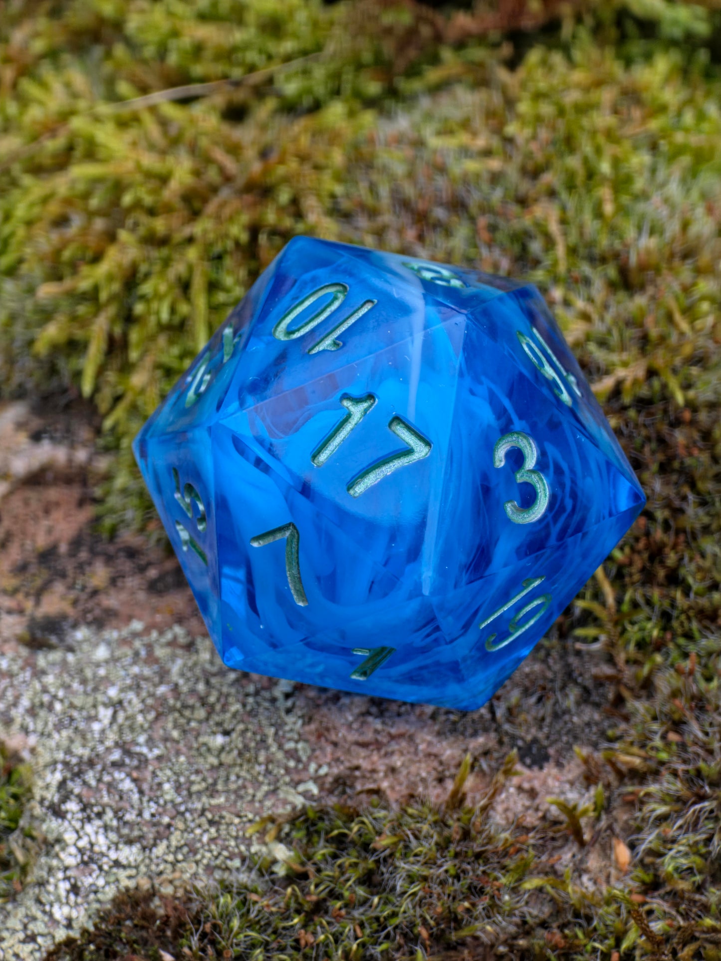Handgemachter polyedrischer D20 „Ocean Blue Cloud“ (35 mm) – tiefblauer Resinwürfel mit wolkenartigem Effekt und goldenen Zahlen.  
Handmade polyhedral D20 “Ocean Blue Cloud” (35 mm) – deep blue resin die with cloudy effect and golden numbers.