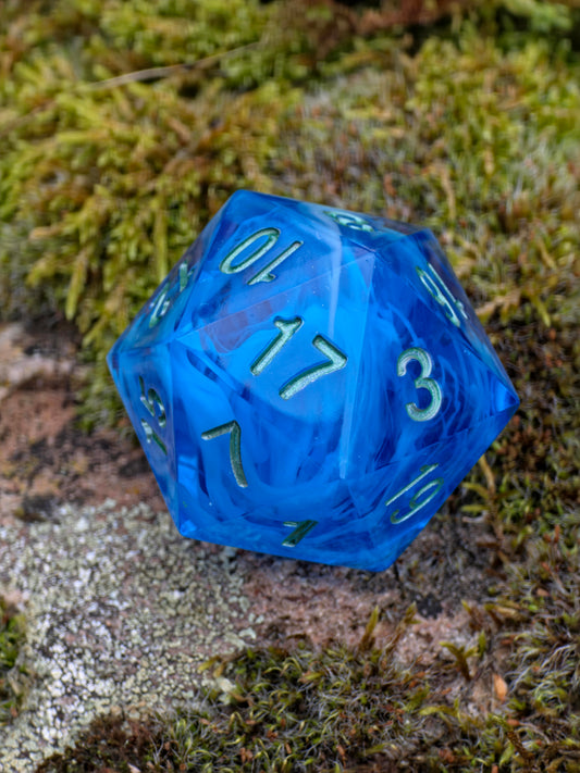 Handgemachter polyedrischer D20 „Ocean Blue Cloud“ (35 mm) – tiefblauer Resinwürfel mit wolkenartigem Effekt und goldenen Zahlen.  
Handmade polyhedral D20 “Ocean Blue Cloud” (35 mm) – deep blue resin die with cloudy effect and golden numbers.
