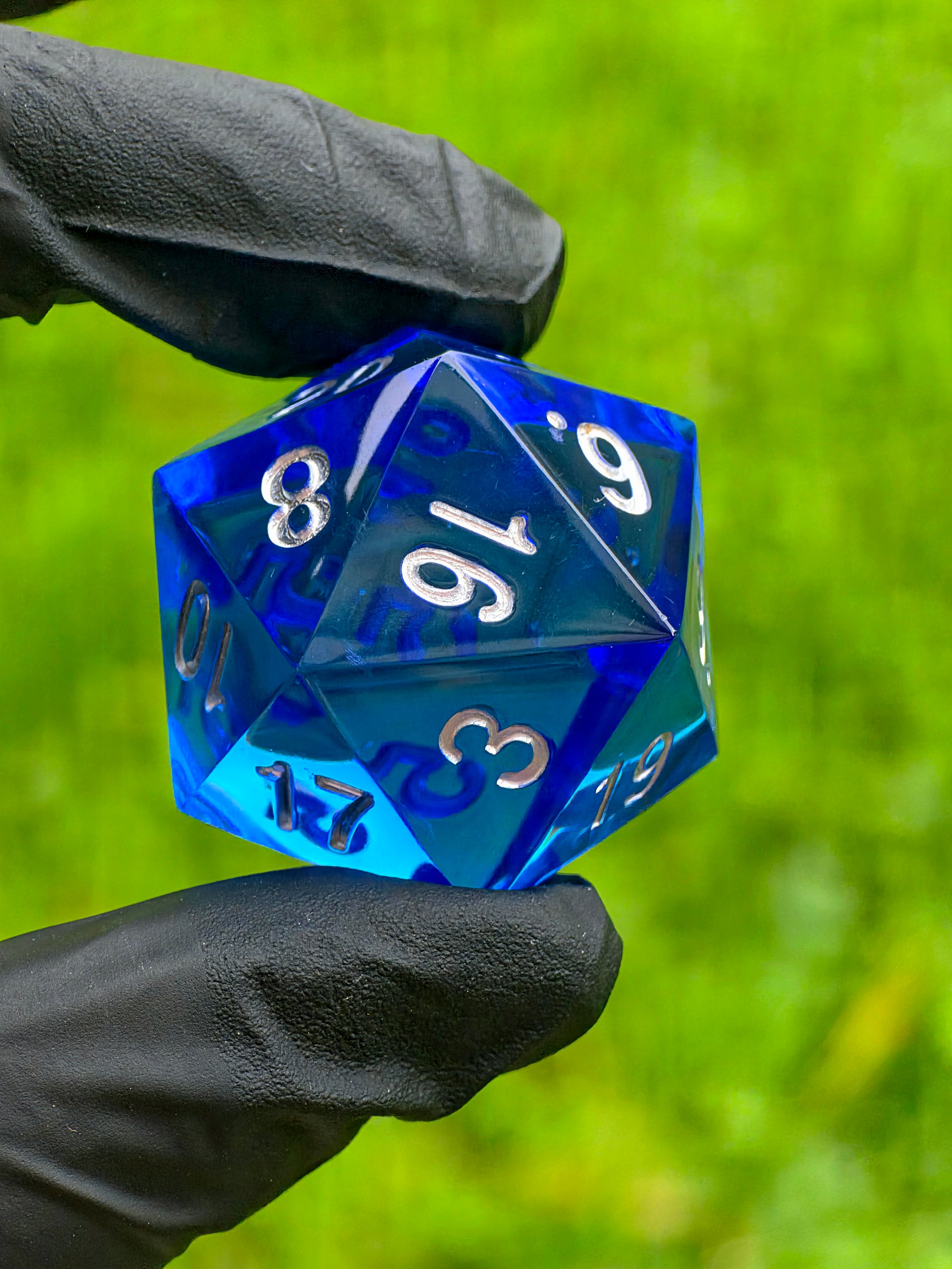 Handgemachter D20-Würfel „Ocean Blue Crystal“ – tiefblaues Harz mit silbernen Zahlen.  
Handmade D20 die “Ocean Blue Crystal” – deep blue resin with silver numbers.