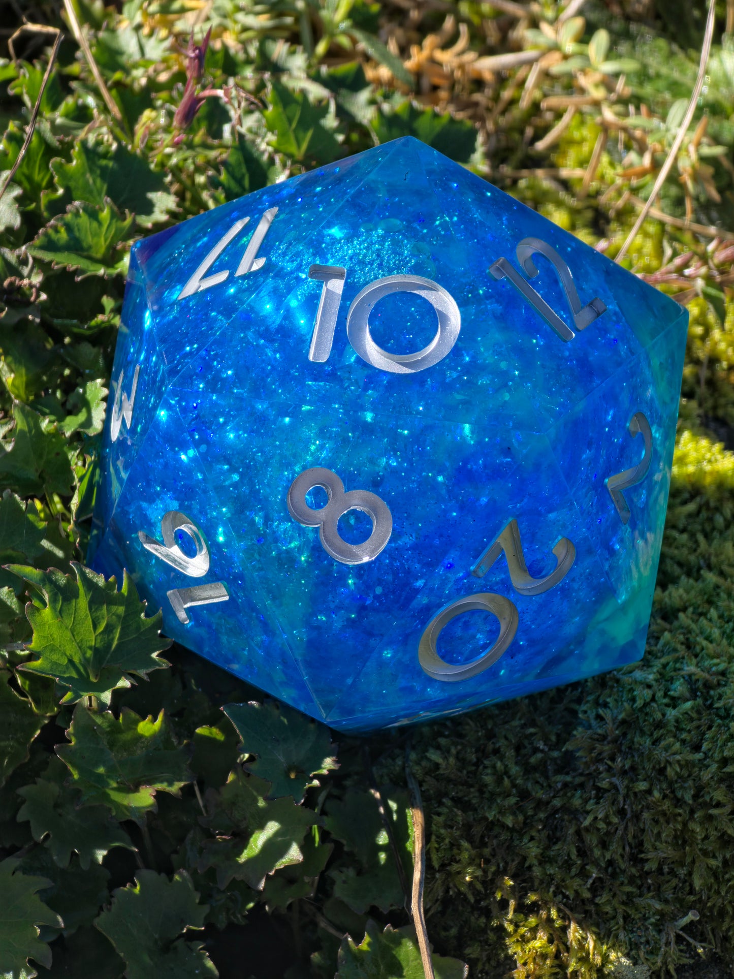 Detailaufnahme des „Ocean Blue Liquid Core“ – schimmernde Partikel und bewegte Flüssigkeit im Inneren.  
Close-up of “Ocean Blue Liquid Core” – shimmering particles and moving liquid inside the core.