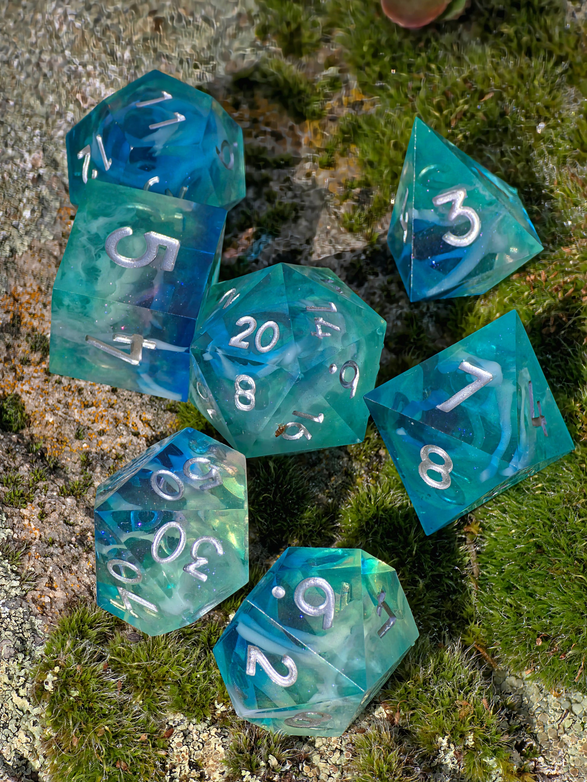 „Ocean Mist Cloud“ in der Hand – klare, glänzende Würfel mit silbernen Zahlen.  
“Ocean Mist Cloud” held in hand – clear, glossy dice with silver numbers.