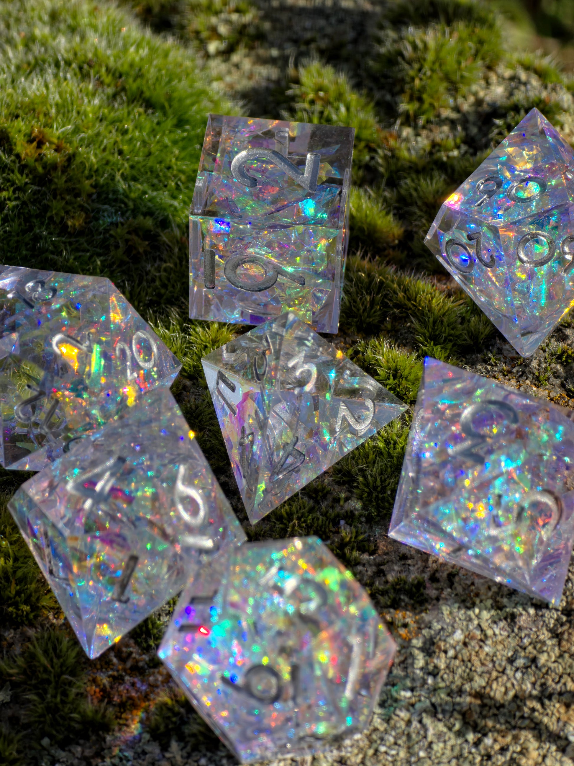 Studioaufnahme des „Opal Aurora“ Würfelsets – klare Struktur, Spiegelglanz und irisierende Farbspiele.  
Studio shot of the “Opal Aurora” dice set – clear structure, mirror gloss and iridescent color play.