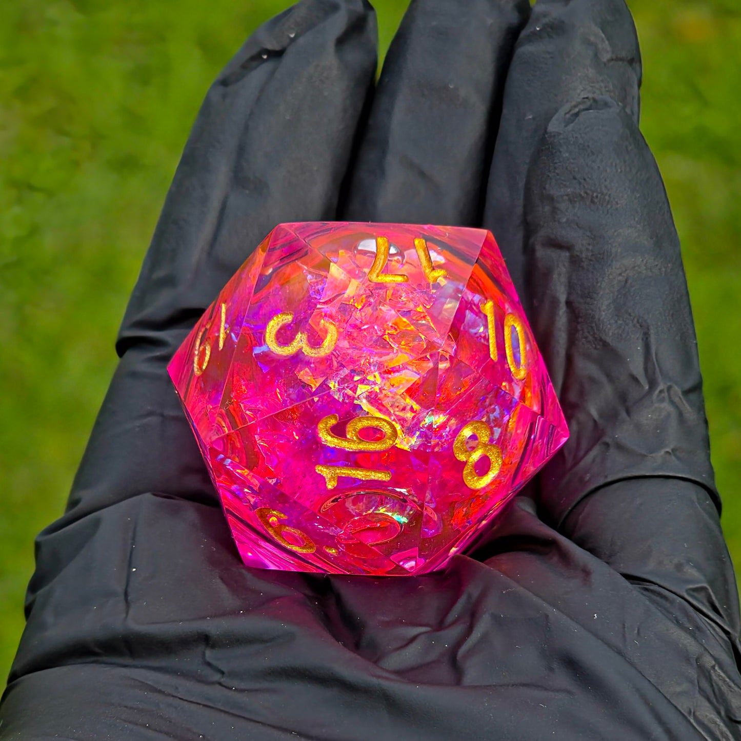 Handgemachter D20 „Pink Aurora“ – großer Liquid Core Würfel in Pink-Gold mit holografischem Glanz.  
Handmade D20 “Pink Aurora” – large liquid core die in pink-gold with holographic shine.