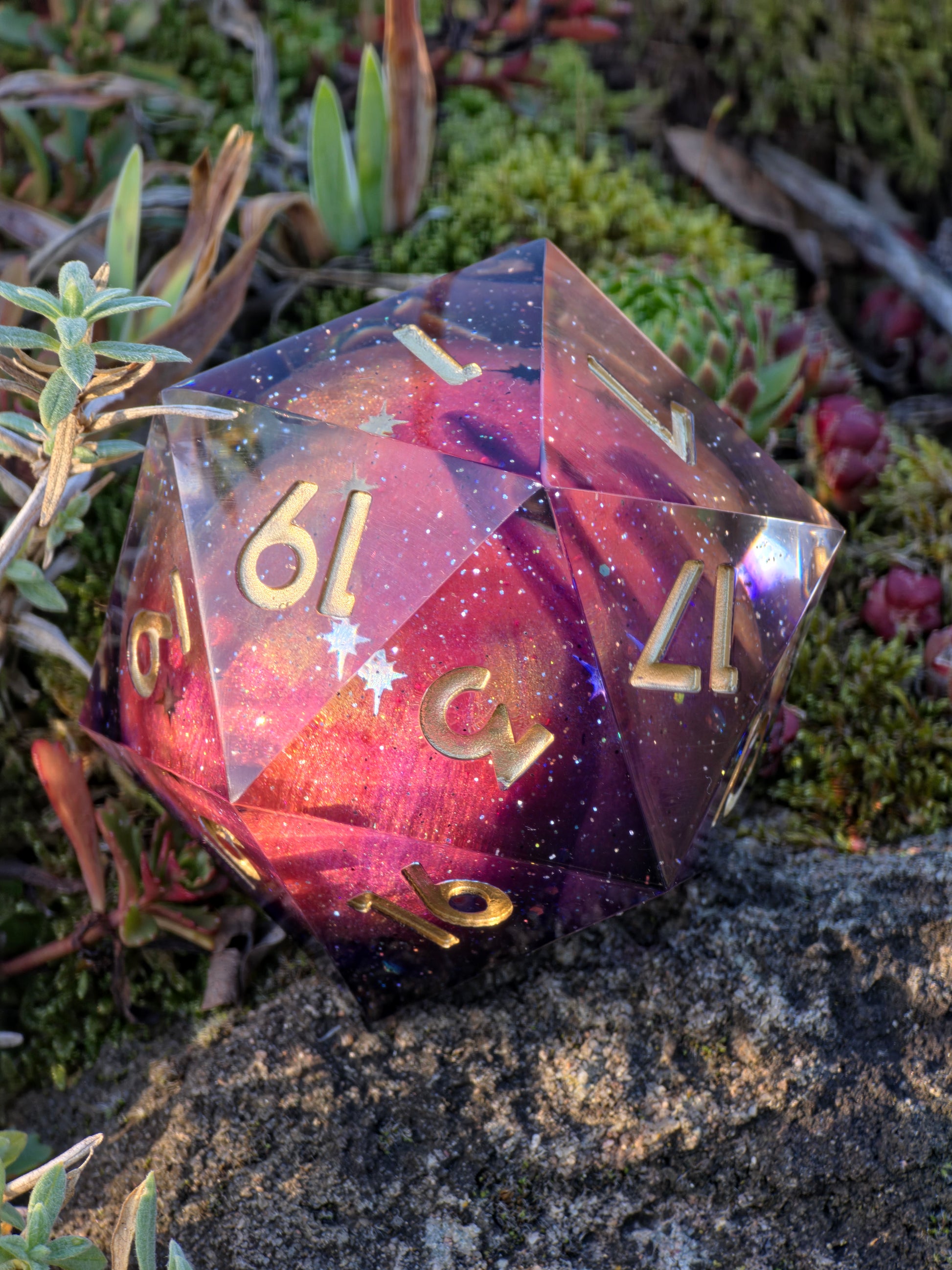 Handgemachter XL D20 „Planet Mars“ – Würfel mit Galaxie-Effekt in Rot, Violett und Gold.  
Handmade XL D20 “Planet Mars” – galaxy effect die in red, violet and gold tones.