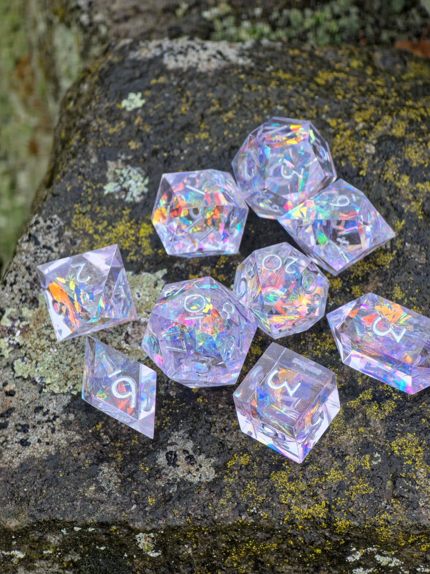 „Prism Aurora“ Würfel in der Hand – zeigt Größe, klare Harzstruktur und Regenbogenglanz.  
“Prism Aurora” dice held in hand – showing size, clear resin structure and rainbow brilliance.