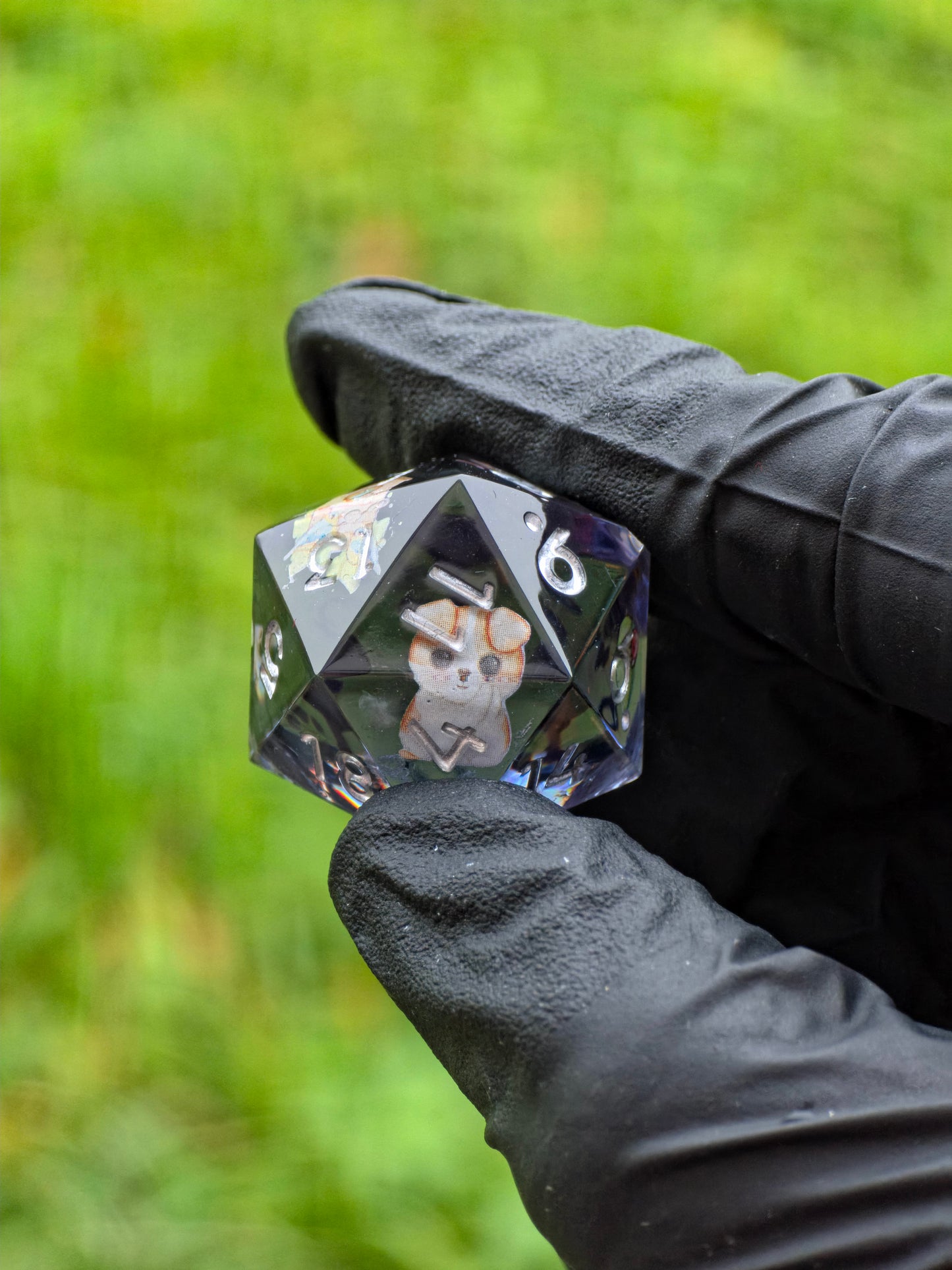 Handgemachter D20 Resinwürfel „Spring Morning“ mit kleinen Figuren von Hund, Vogelhaus und Vögeln – Symbol des Frühlings.  
Handmade D20 resin die “Spring Morning” with tiny dog, birdhouse and birds inside – a symbol of spring’s gentle spirit.