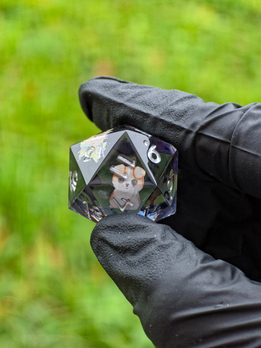 Handgemachter D20 Resinwürfel „Spring Morning“ mit kleinen Figuren von Hund, Vogelhaus und Vögeln – Symbol des Frühlings.  
Handmade D20 resin die “Spring Morning” with tiny dog, birdhouse and birds inside – a symbol of spring’s gentle spirit.