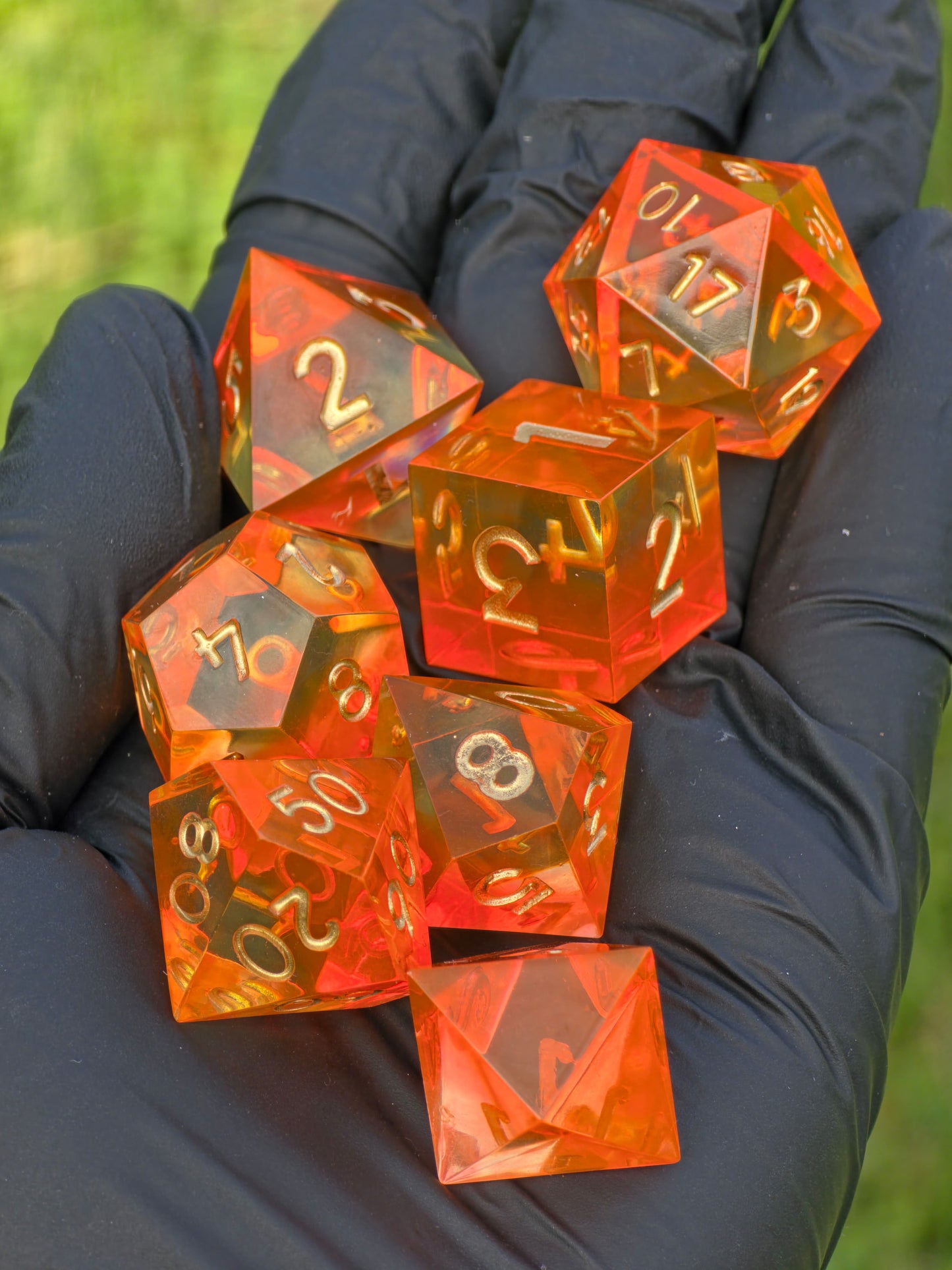 „Sunflare“ in der Hand – goldene Gravuren auf sonnendurchflutetem Harz.  
“Sunflare” held in hand – golden engravings on sunlit resin.