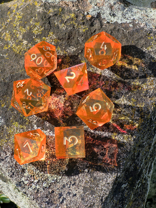 Handgemachtes DnD-Würfelset „Sunflare“ – transparente Würfel in Orange und Gelb mit goldenen Zahlen.  
Handmade DnD dice set “Sunflare” – transparent dice in orange and yellow tones with golden numbers.